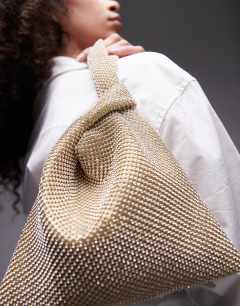 Model wearing Gwyn embellished knot grab bag in gold
