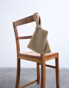 Model wearing Gwyn embellished knot grab bag in gold