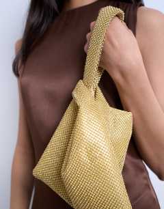 Model wearing Gywn embellished knot grab bag in gold