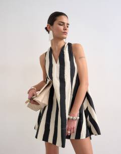 Model wearing Halter deep hem mini trapeze dress in mono stripe