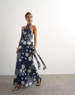 Model wearing Halter neck dropped waist tie detail maxi dress in black mixed spot