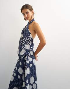 Model wearing Halter neck dropped waist tie detail maxi dress in black mixed spot
