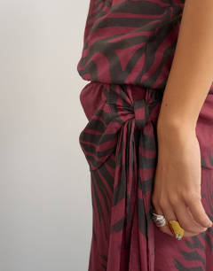Model wearing Halter neck dropped waist tie detail maxi dress in burgundy zebra print