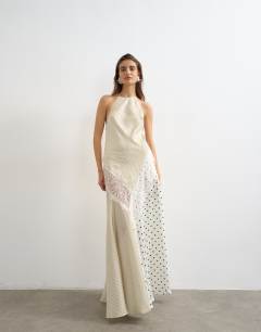 Model wearing Halter neck lace insert maxi dress om contrast stripe and polka dot print