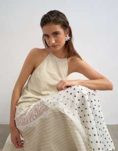 Model wearing Halter neck lace insert maxi dress om contrast stripe and polka dot print