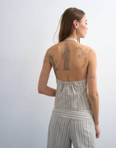 Model wearing Halter with key hole detail in woven black stripe