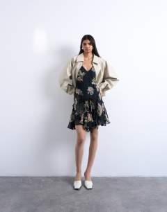 Model wearing Hanky hem mini dress with pinched straps in black based floral