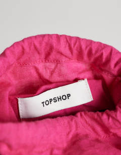 Model wearing Harper tassel straw grab bag in pink