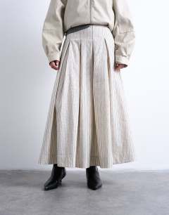 Model wearing Heavy pleated maxi full circle skirt in woven mono stripe