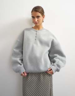 Model wearing Henley button detail sweat in grey marl
