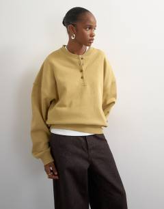 Model wearing Henley button detail sweat in soft khaki