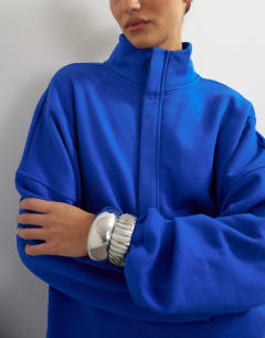 Model wearing High neck concealed placket sweat in colbalt