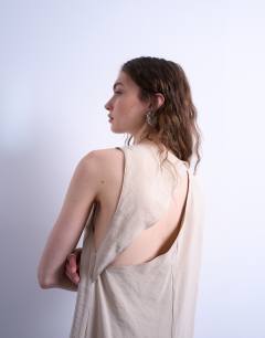 Model wearing High neck open back chuck on cupro midi dress in buttermilk