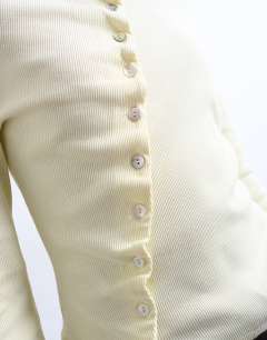 Model wearing High neck ruffle button long sleeve top in buttermilk