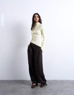 Model wearing High neck ruffle button long sleeve top in buttermilk