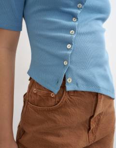 Model wearing High neck ruffle button through half sleeve top in dusty blue