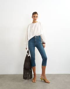 Model wearing High rise capris jean in vintage blue