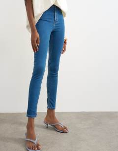 Model wearing High rise skinny jean in vintage blue