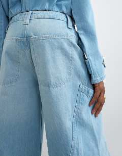 Model wearing High rise utility barrel jean in bleach