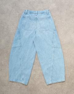 Model wearing High rise utility barrel jean in bleach