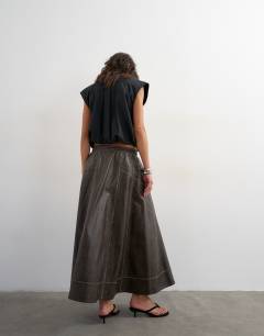 Model wearing High shine leather look maxii skirt with side pockets in washed brown