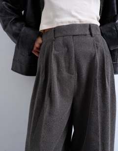 Model wearing High waisted two pleat herringbone pleated front trouser in grey