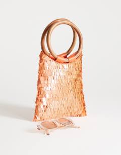 Model wearing Holly sequin grab bag with wooden handle in coral