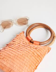 Model wearing Holly sequin grab bag with wooden handle in coral
