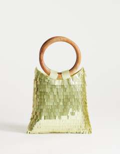 Model wearing Holly sequin grab bag with wooden handle in lime