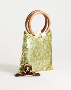 Model wearing Holly sequin grab bag with wooden handle in lime