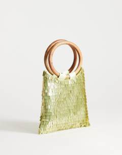 Model wearing Holly sequin grab bag with wooden handle in lime