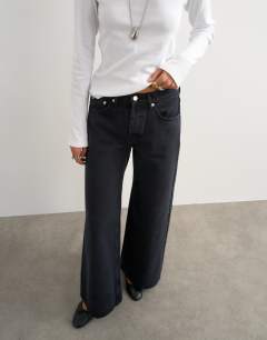 Model wearing Horizon mid rise wide leg jean in blue black