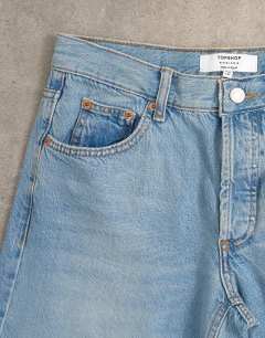 Model wearing Horizon mid rise wide leg jean with let down hem detail in vintage blue