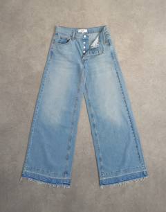 Model wearing Horizon mid rise wide leg jean with let down hem detail in vintage blue