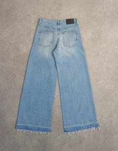 Model wearing Horizon mid rise wide leg jean with let down hem detail in vintage blue