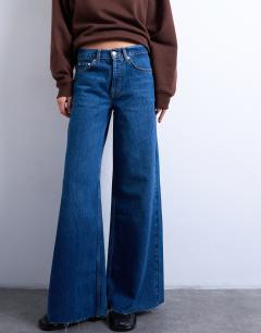 Model wearing Horizon mid rise wide leg jean with raw hem in rich blue