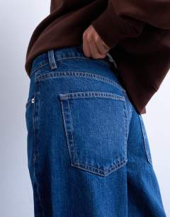 Model wearing Horizon mid rise wide leg jean with raw hem in rich blue