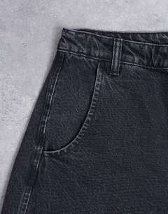 Model wearing Horseshoe high rise barrel jean circular design in washed black