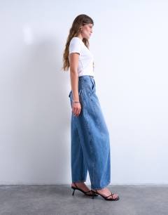 Model wearing Horseshoe high rise barrel jean in mid blue
