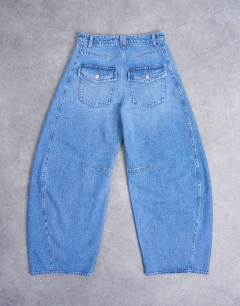 Model wearing Horseshoe high rise barrel jean in mid blue