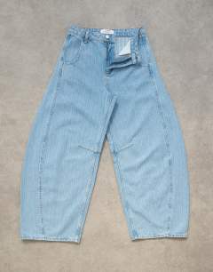 Model wearing Horseshoe mid rise barrel jean in bleach stripe