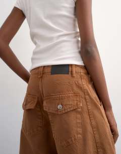 Model wearing Horseshoe mid rise barrel jean in toffee