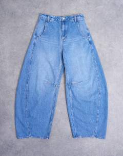 Model wearing Horseshoe mid rise barrel jean in vintage blue