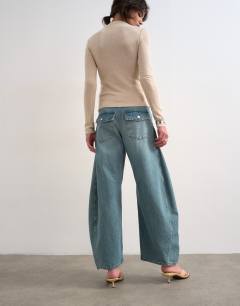 Model wearing Horseshoe mid rise barrel leg jean in green cast