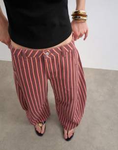 Model wearing Horseshoe mid rise jean in pink and red stripe