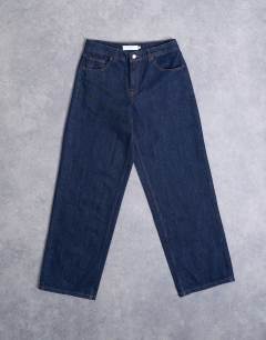 Model wearing Hourglass Cinch low rise relaxed jean in raw look indigo 