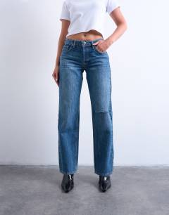 Model wearing Hourglass Ember low rise straight leg jean with knee rip in mid blue