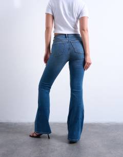 Model wearing Hourglass Jamie Flare high rise jeans in vintage blue
