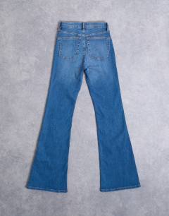 Model wearing Hourglass Jamie Flare high rise jeans in vintage blue