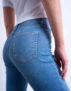 Model wearing Hourglass Jamie high rise skinny jean in vintage blue